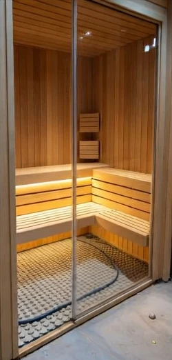Puuverhoiltu sauna lasiovella kylpyhuoneen yhteydessä